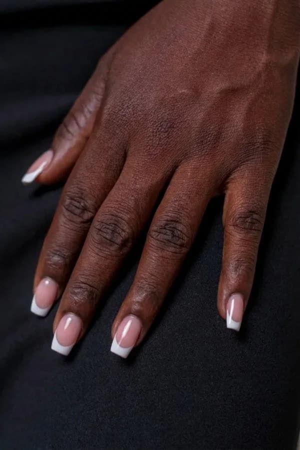The same hand with a classic French manicure