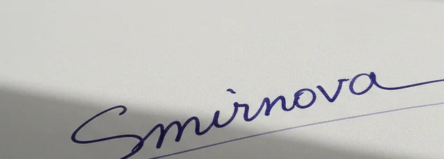 Photo of a blue pen signature on paper with a shadow